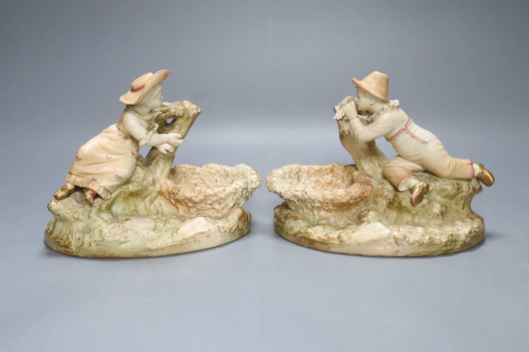 A pair of Worcester James Hadley blush ivory figural dishes, height 15cm